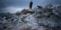 Man standing on top of rubble in Turkey-Syria earthquake zone